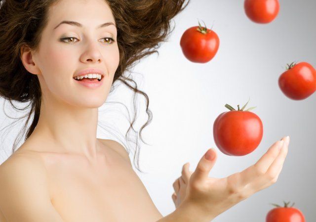 una niña con un tomate rojo maduro